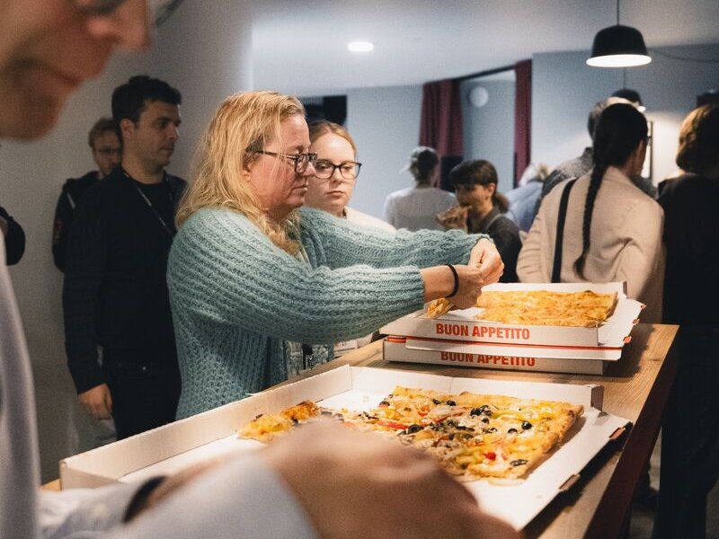 Teilnehmende holen sich zum Ausklang des TestLänd After Work #6 Pizza aus den Kartons.