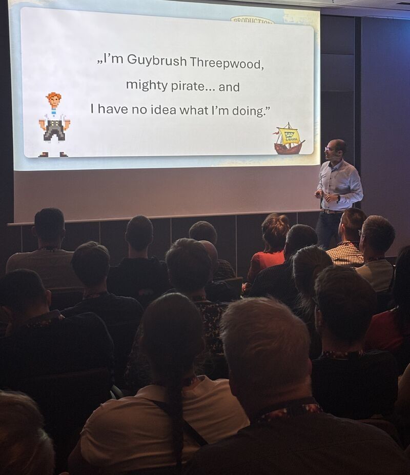 Matthias Groß im Vortrag vor Publikum, auf der Folie das Zitat I'm Guybrush Threepwood, mighty pirate.