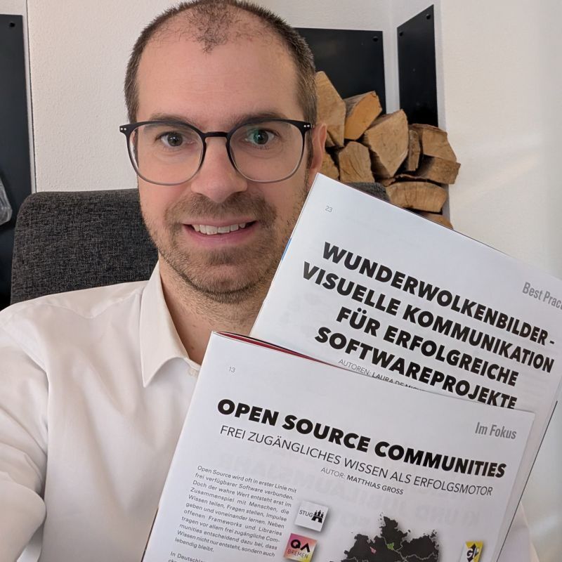 Matthias Groß hält zwei ausgedruckte SQ-Magazin-Artikel in die Kamera.