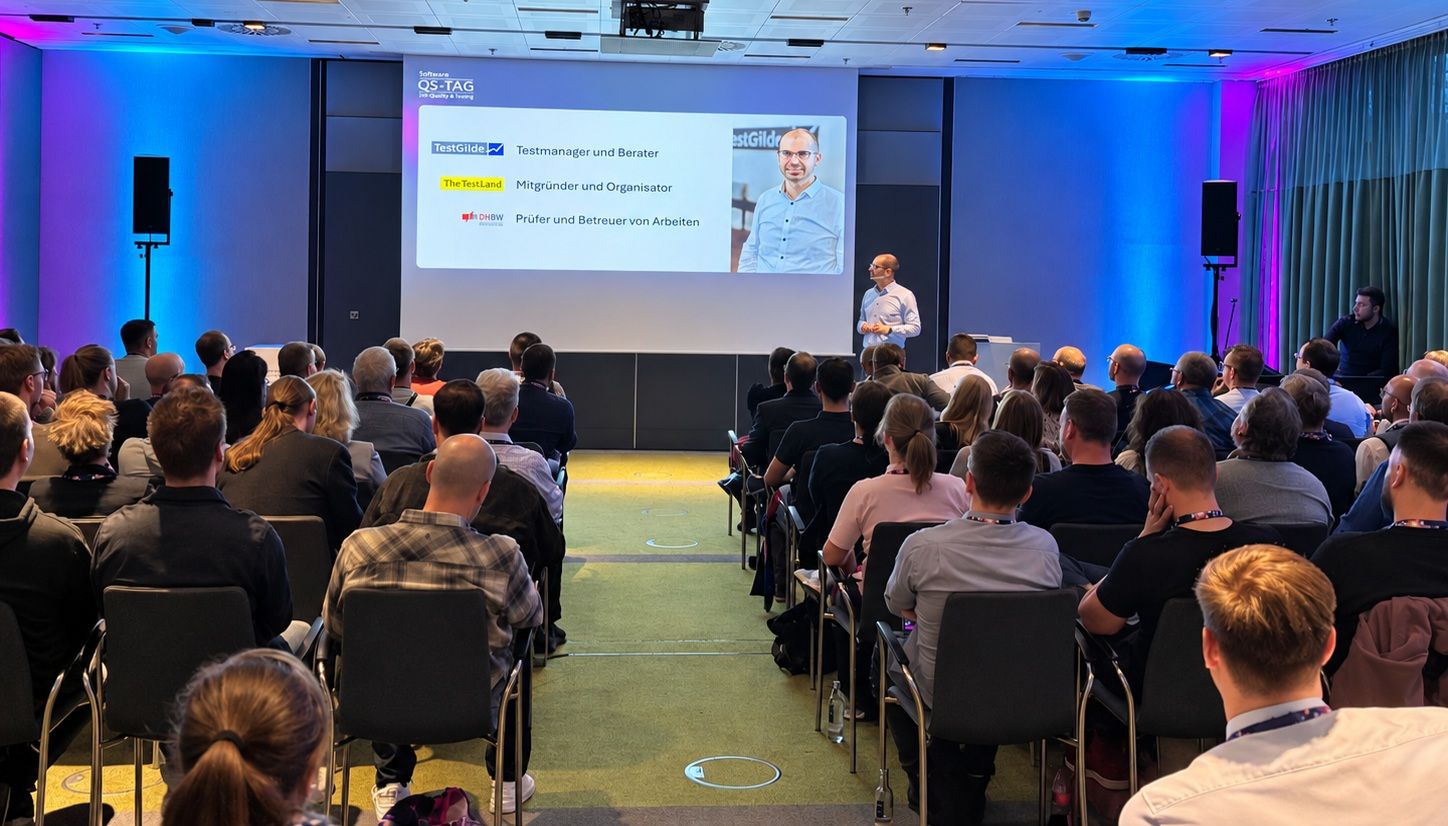 Matthias Groß hält den Vortrag Kapitän im Sturm vor vollem Saal beim Software-QS-Tag, im Hintergrund die Folie mit seinen Rollen bei TestGilde, TestLänd und der DHBW.