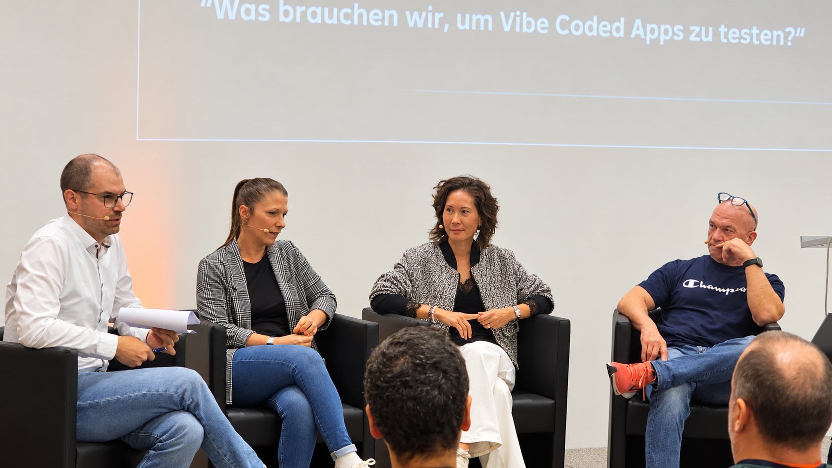 Moderator Matthias Groß im Gespräch mit den Panelistinnen und dem Panelisten Pia Wiedermayer, Erika Goericke und Rudolf Grötz auf der Bühne beim German Testing Day.